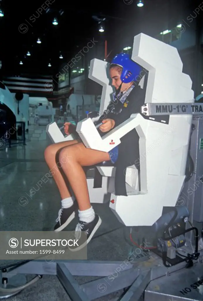 A girl attending space camp at the George C. Marshall Space Flight Center in Huntsville, Alabama, tries a MMU 1-G Trainer