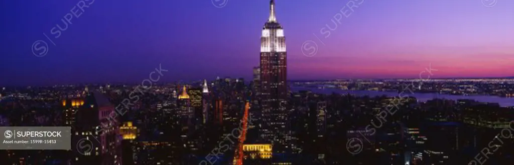 This is the Empire State Building at sunset.  The World Trade Center is on the left, the Statue of Liberty is on the right. This is the view from 42nd Street & 5th Avenue.