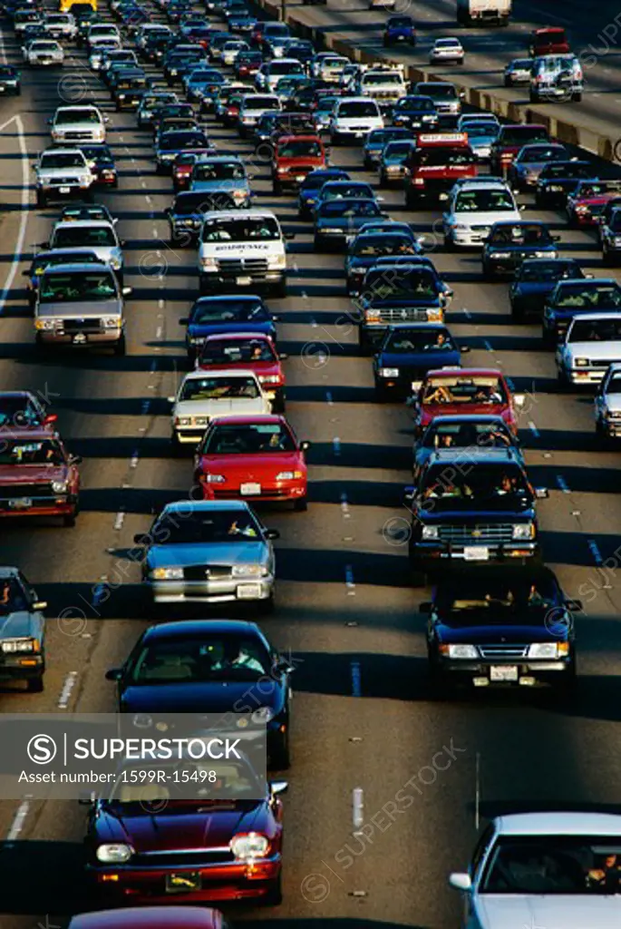 This is a vertical image of rush hour traffic on the 405 Freeway in Los Angeles. There are several lanes of traffic completely filled with cars. The cars are bumper to bumper.