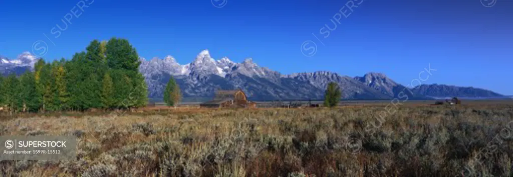 This is Grand Teton National Park. There is a pioneer farm with the Tetons behind it. It is located off Highway 89.