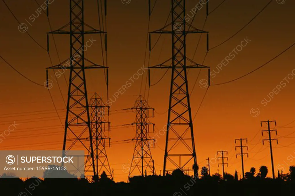 Power lines silhouetted by setting sun