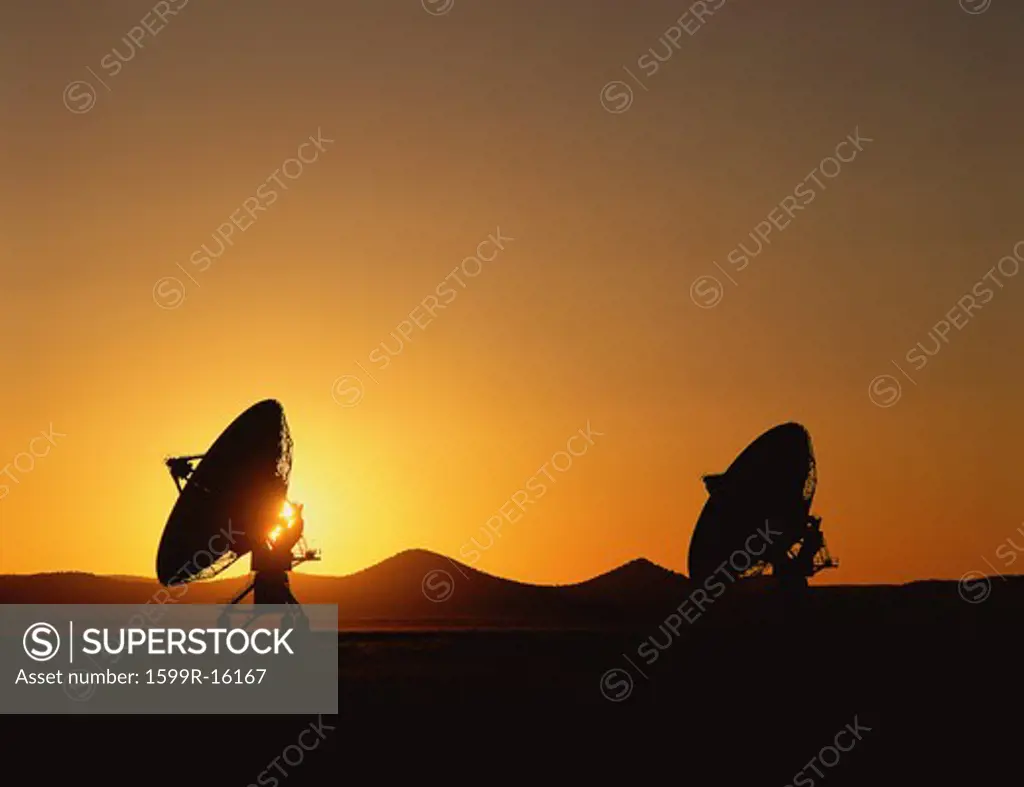 Silhouetted VLA Very Large Array radio telescope dishes