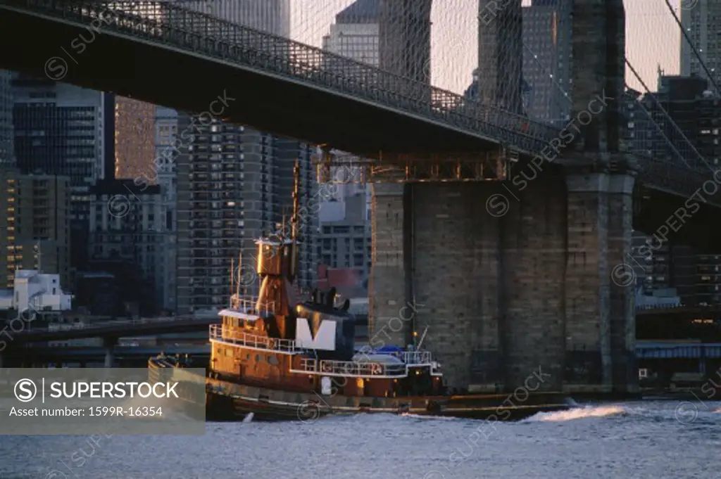 Tug boat under Brooklyn Bridge, New York