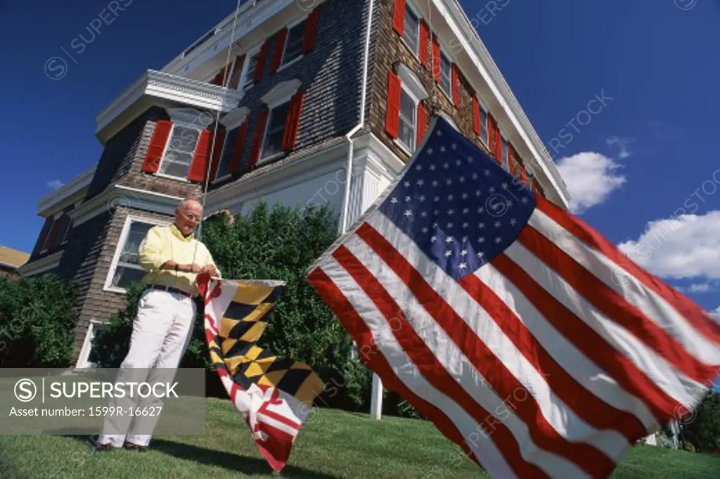 Older man hanging American and state flags