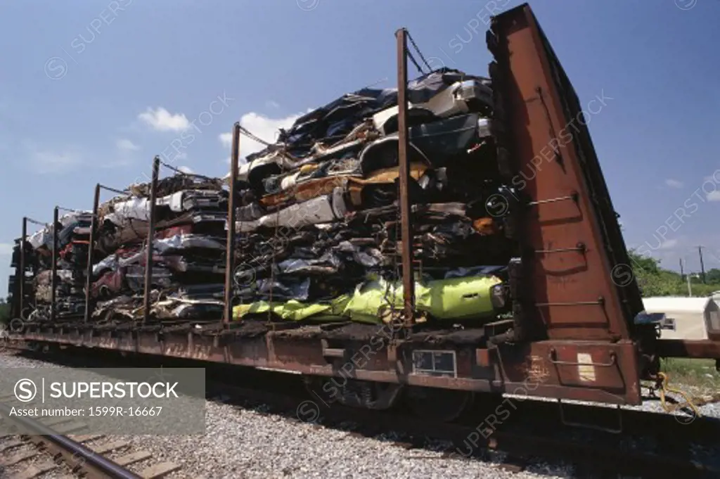 Junked smashed cars on railroad car
