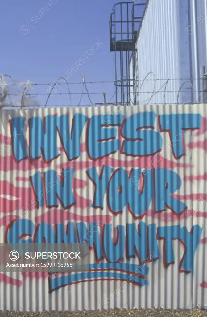 Invest in your community statement painted on a fence during the Los Angeles riots