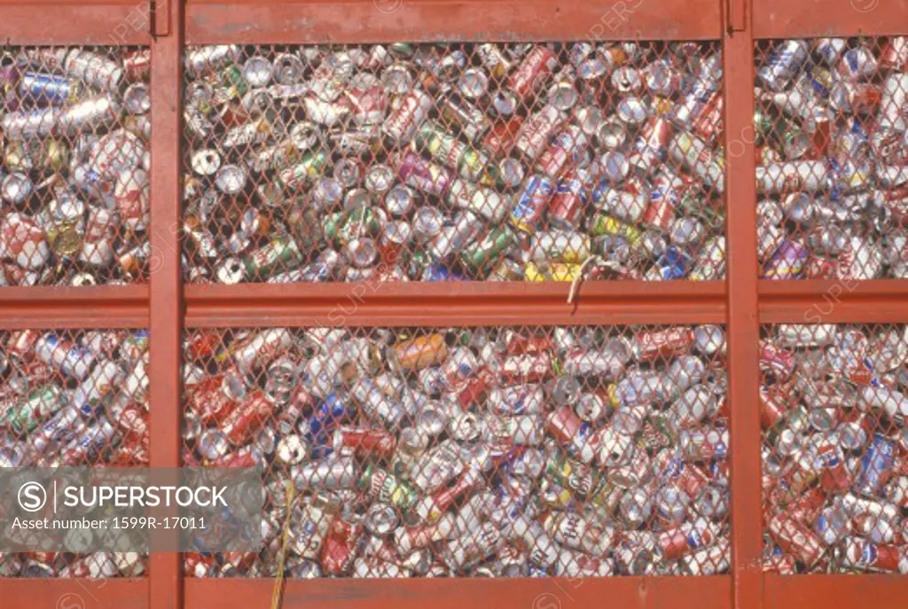 A recycling bin full of cans waiting for processing
