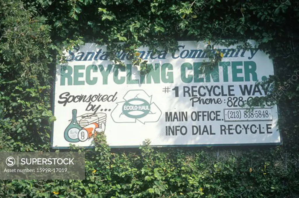 A sign for the Santa Monica Community Recycling Center obscured by leaves