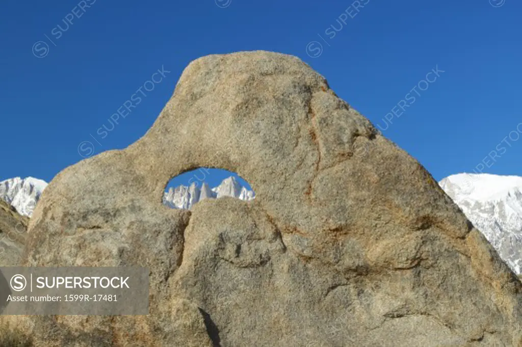 The Alabama Hills hole in rock framing Mount Whitney and the snowy Sierra Mountains at sunrise near Lone Pine, CA