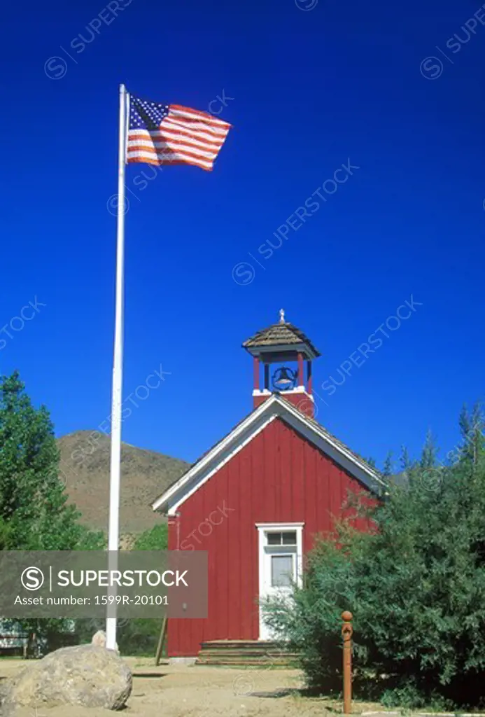 American flag waving above one room schoolhouse, Wellington, NV