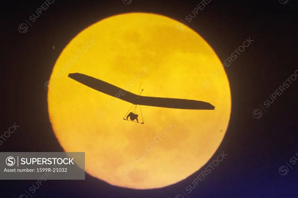 Silhouette of Hang Glider against full moon, special effect
