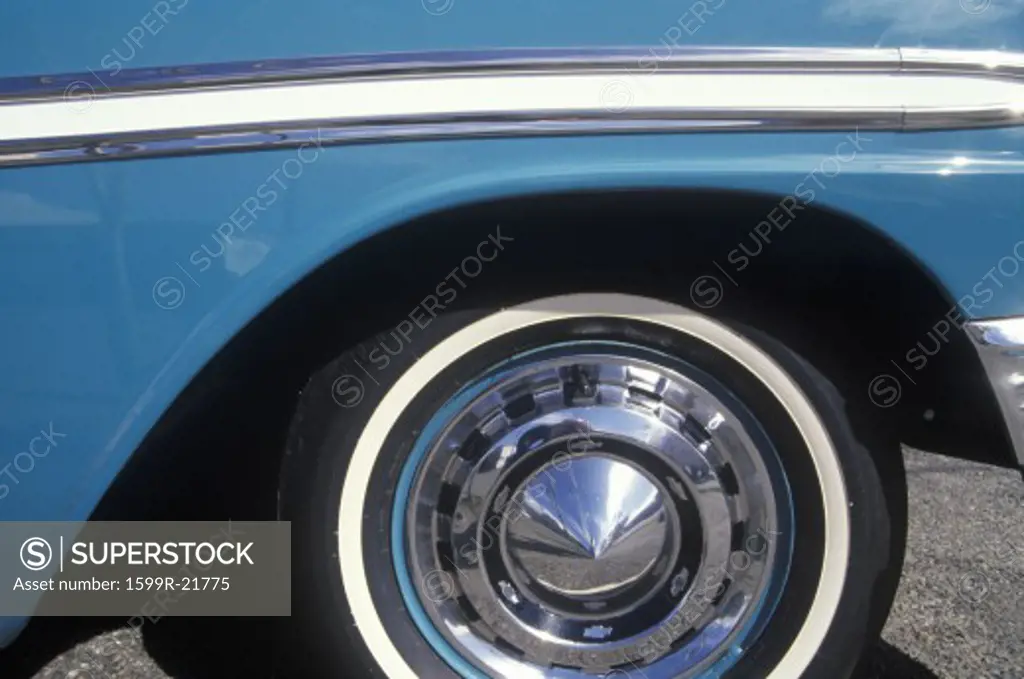 A side wheel and panel of a blue 1956 Chevrolet