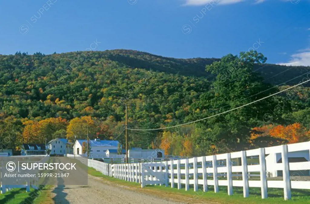 A white fence leading to a home in New Hampshire