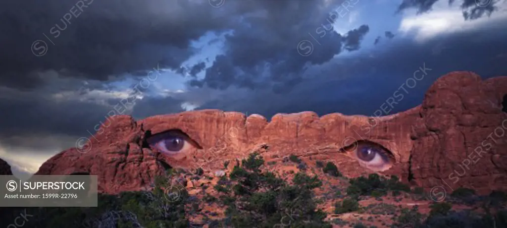 Composite image of a rock formation with window arches in the western desert with eyes peering through