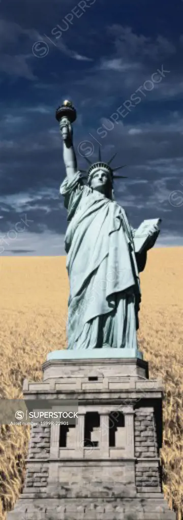 Composite image of the Statue of Liberty and pedestal against a wheat field