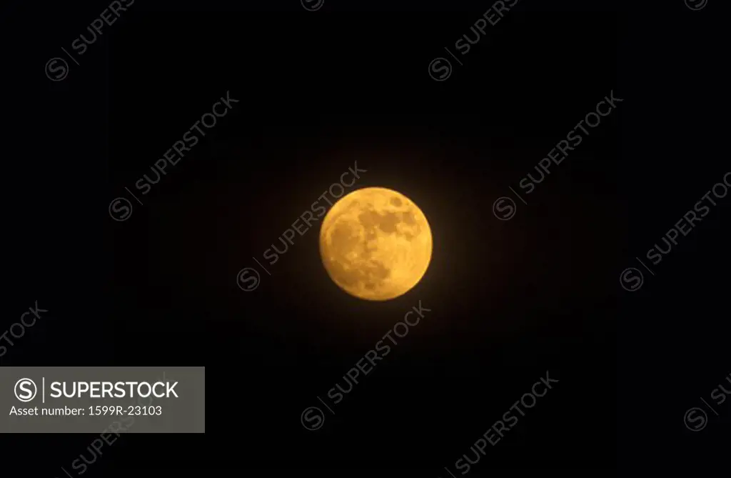 A full moon against a black starless sky