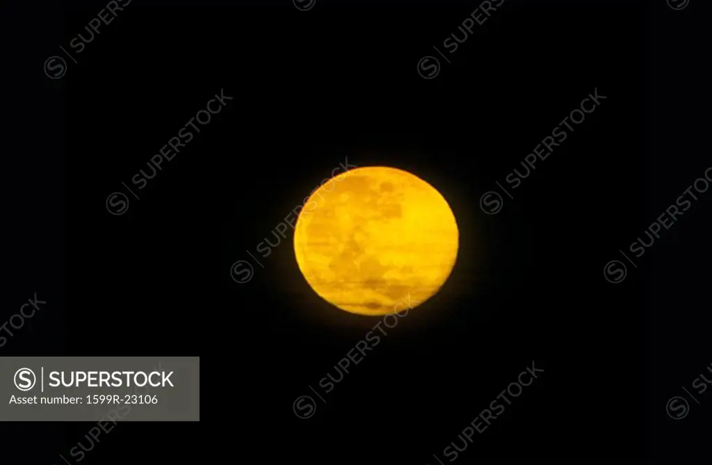 A full moon against a black starless sky