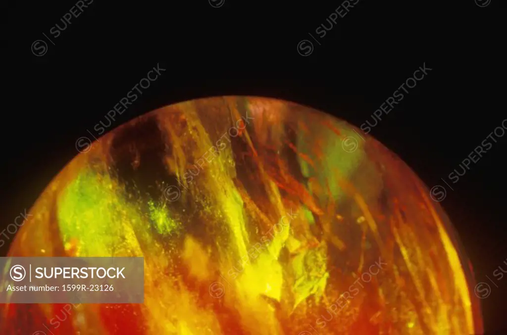 A glowing crystal sphere as orange laser light shines through