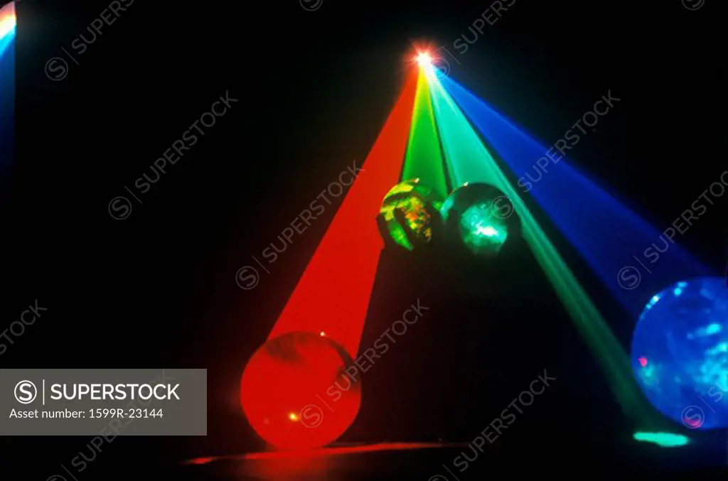 Several multi-colored spheres appearing as planets with laser lights shining through