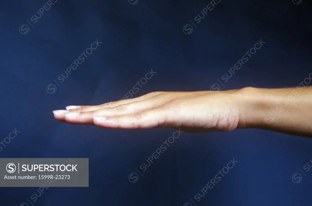Side view of hand against dark blue sky
