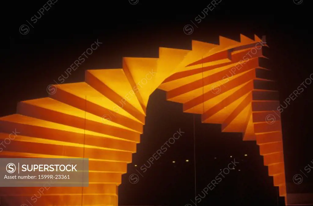 Orange sculpture shaped as a stairway at night