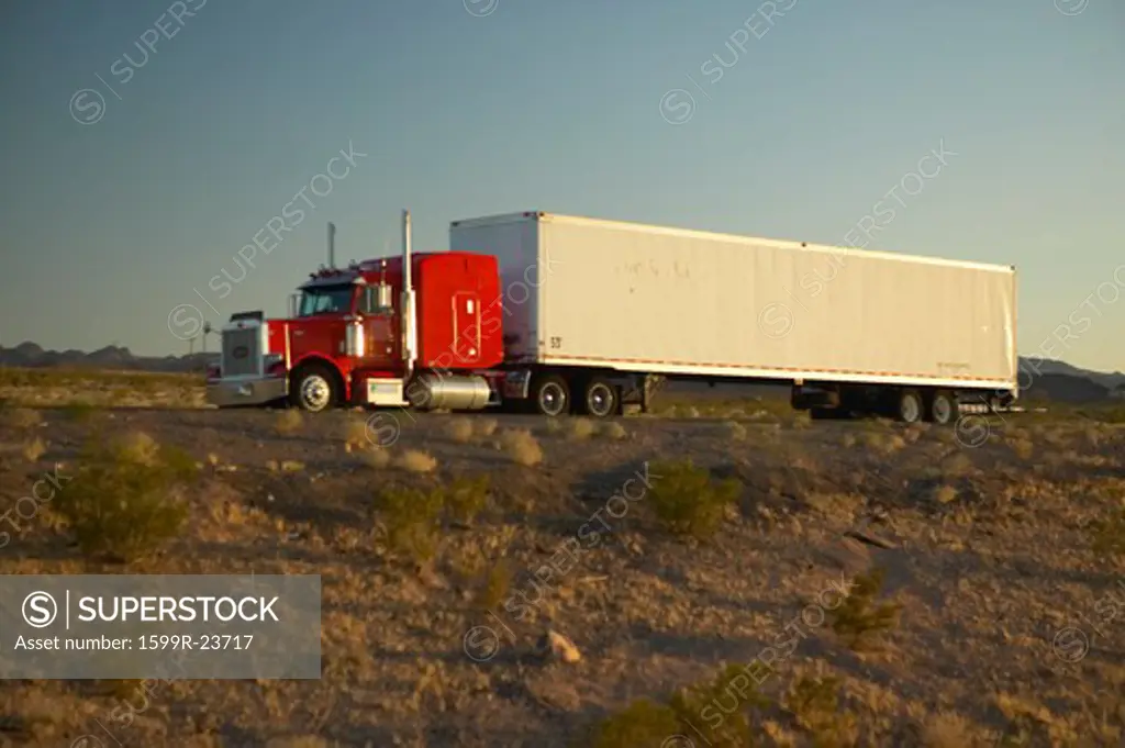 18-wheeler semi-trucks hit the highway driving down Interstate Highway 15 between Los Angeles and Las Vegas Nevada.