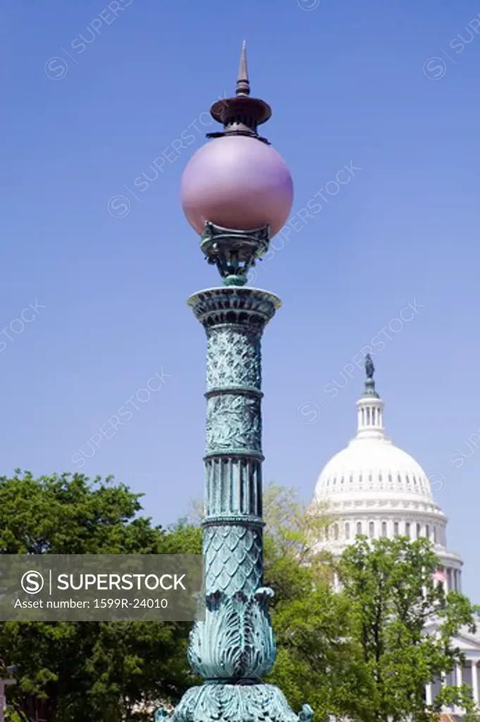 Street lamp of Library of Congress towers over U.S. Capitol Dome, Washington D.C.