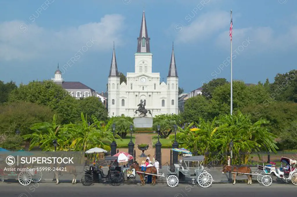 Horse Carriage and tourists in front of Andrew Jackson Statue & St. Louis Cathedral, Jackson Square in New Orleans, Louisiana