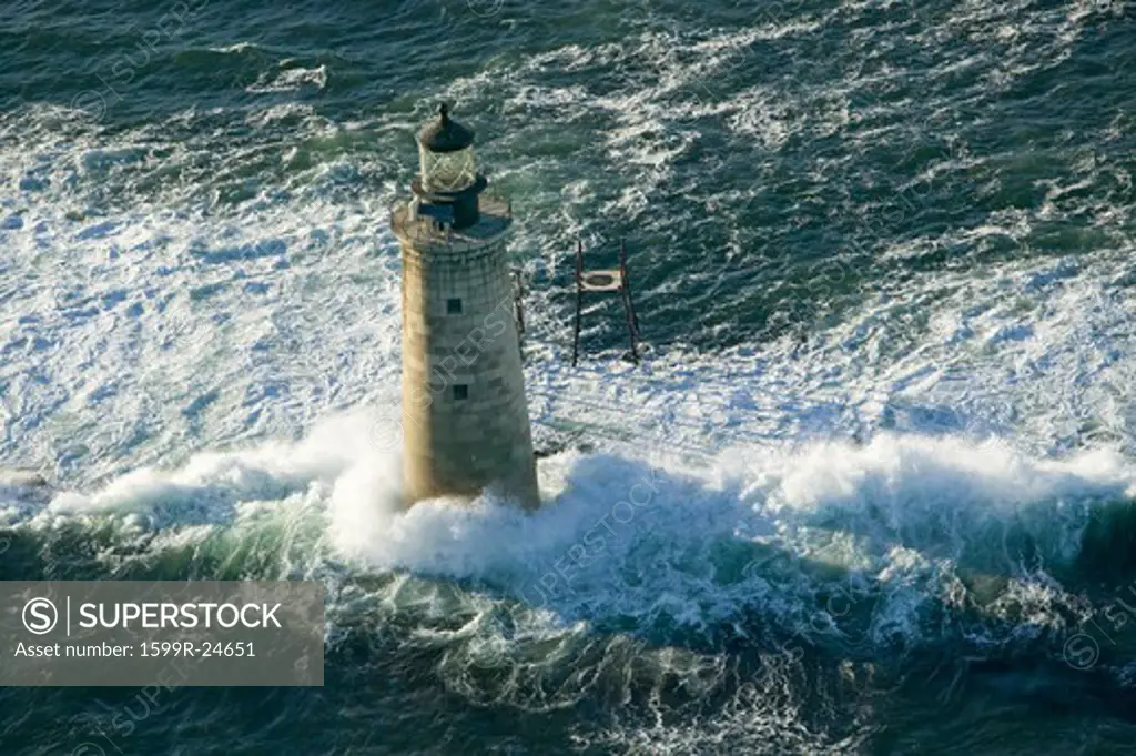 Aerial view of lighthouse at sea surrounded by water on Maine coastline, south of Portland
