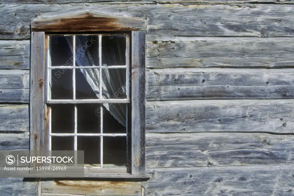 Window with curtain in log building in Ghost Town near Virginia City, MT