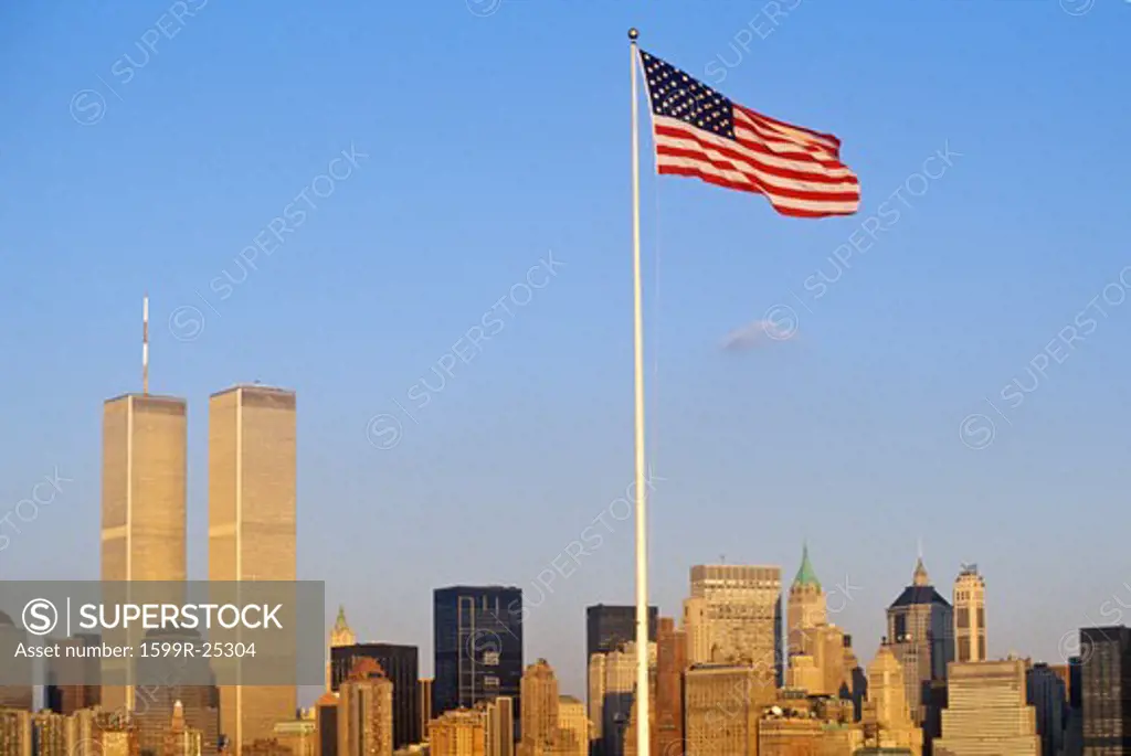 American Flag flying over skyline of New York City from New York Harbor, NY