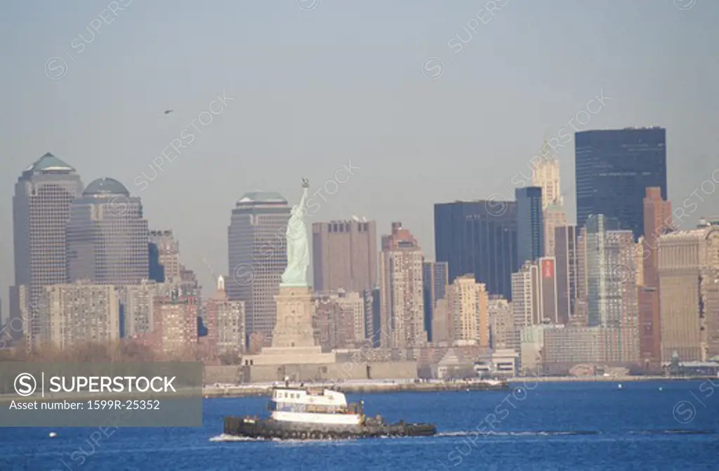 Statue of Liberty and tugboat post 9/11 without World Trade Towers, Manhattan skyline, NY