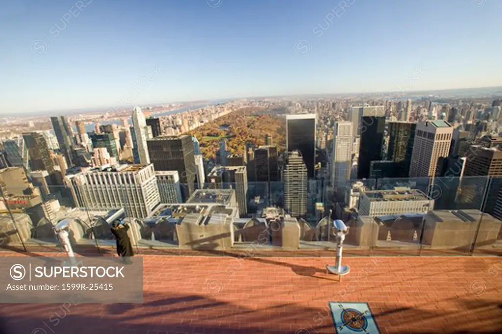 Girl looking at panoramic view of New York City and Central Park from Top of the Rock viewing area at Rockefeller Center, New York City, New York