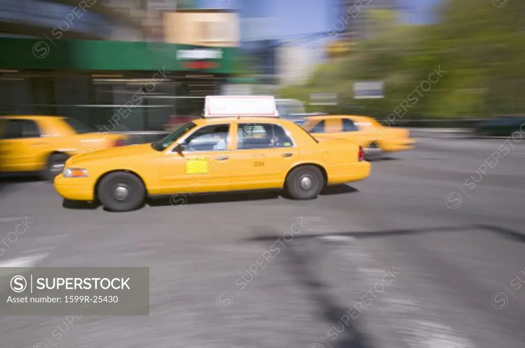 Blurred yellow taxies speed by in Manhattan, New York City, New York