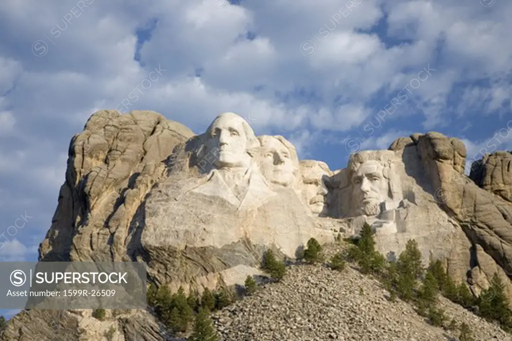 White puffy clouds behind Presidents George Washington, Thomas Jefferson, Teddy Roosevelt and Abraham Lincoln at Mount Rushmore National Memorial, South Dakota