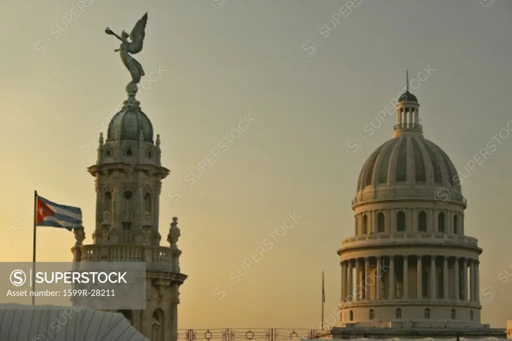 Cuban flag at sunrise with the Roofs of Opera House, Dome of the Royal Theater and Capitol, Havana