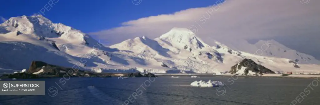 Panoramic view of ecological tourists in inflatable Zodiac boats, snowy mountains, glaciers and icebergs at Half Moon Island, Bransfield Strait, Antarctica