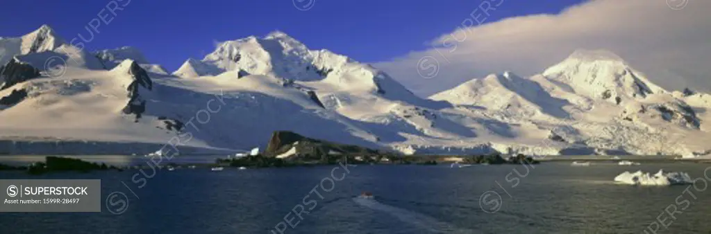 Panoramic view of ecological tourists in inflatable Zodiac boats, snowy mountains, glaciers and icebergs at Half Moon Island, Bransfield Strait, Antarctica