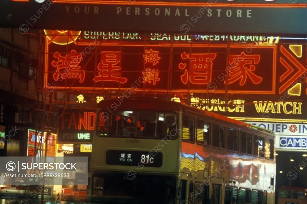 Double decker bus and neon signs in business district of Hong Kong at night