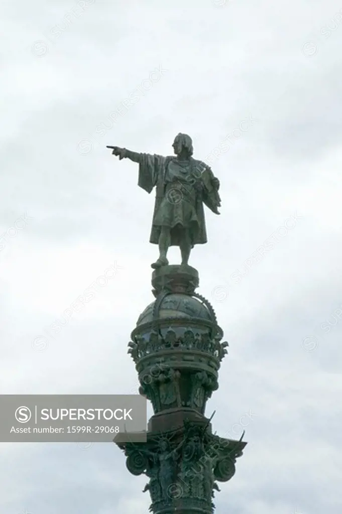 Statue of Christopher Columbus points west over Atlantic Ocean to New World, waterfront of Port Vell, Barcelona, Spain