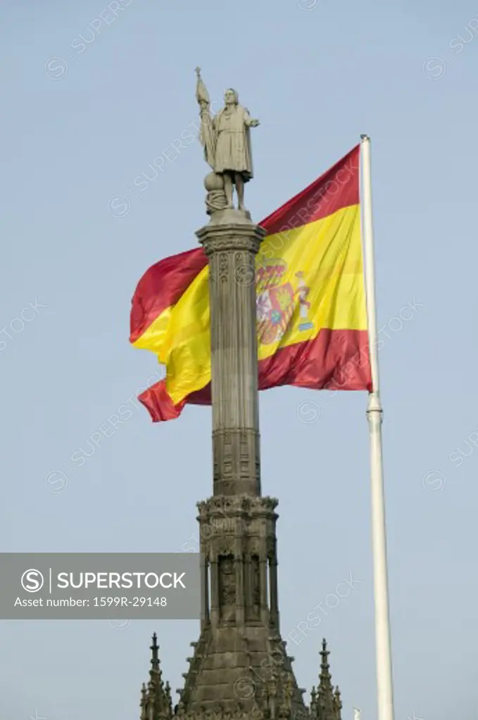 Spanish flag waves behind statue of Christopher Columbus, Plaza de Colón in Madrid, Spain