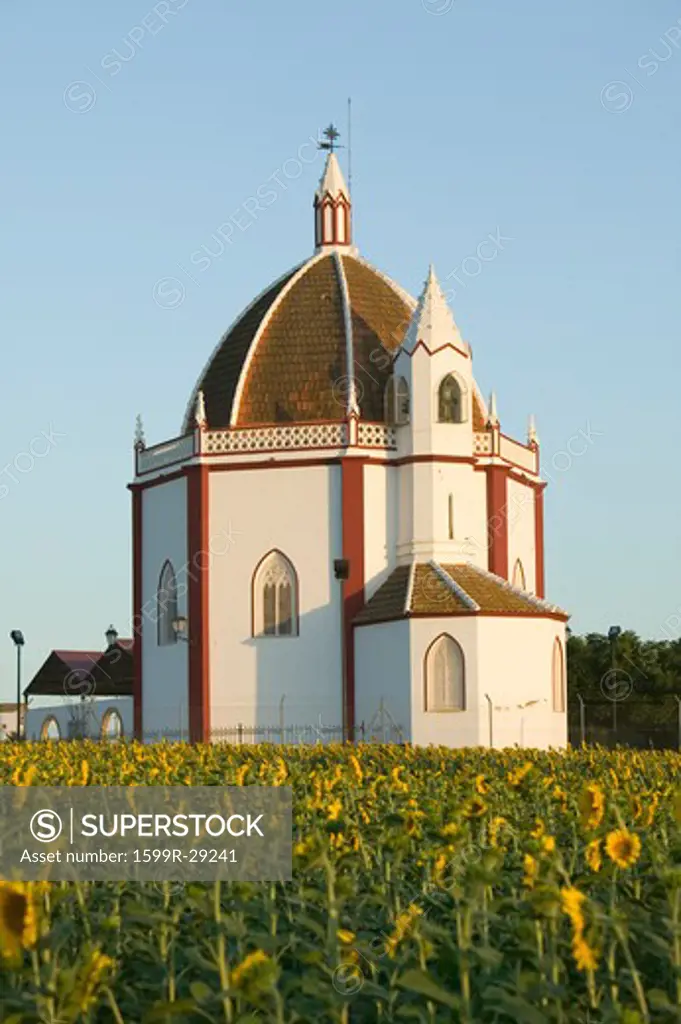 Moorish building in field of sunflowers in late afternoon sunlight outside of Sevilla, southern Spain
