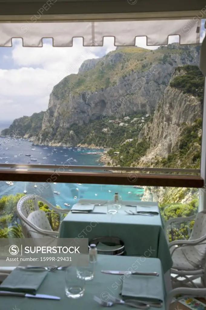 Dining table overlooking City of Capri, an Italian island off the Sorrentine Peninsula on the south side of Gulf of Naples, in the region of Campania, Province of Naples, Italy, Europe