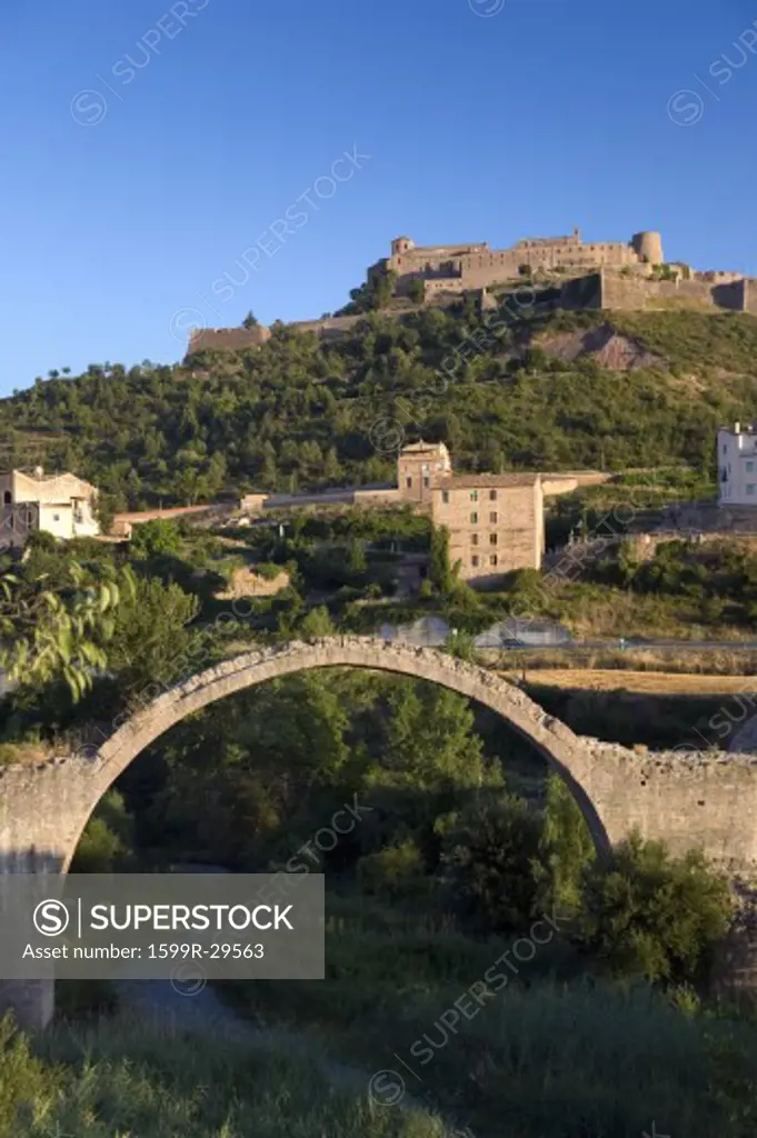 Ancient stone arch bridges with a background of Parador de Cardona, a 9th Century medieval hillside Castle, near Barcelona, Catalonia, Cardona, Spain