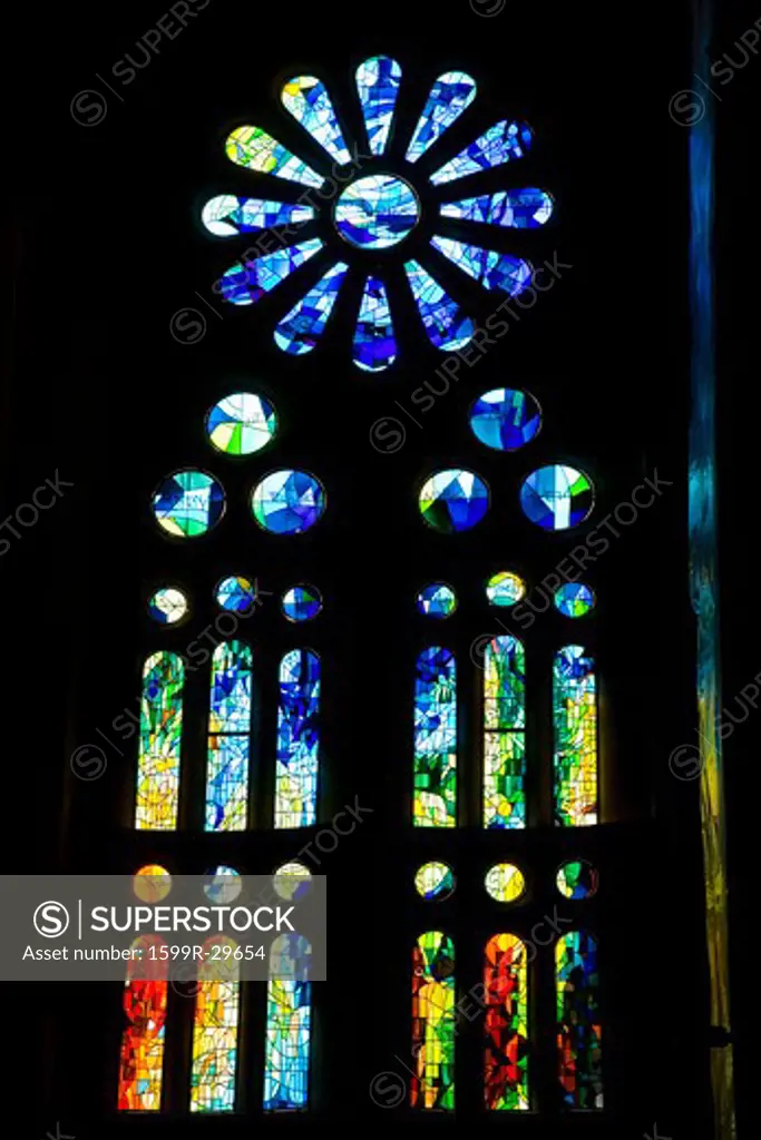 Stain glass of Sagrada Familia Holy Family Church by architect Antoni Gaudi, Barcelona, Spain begun in 1882 and continuing to be built into the 21st Century