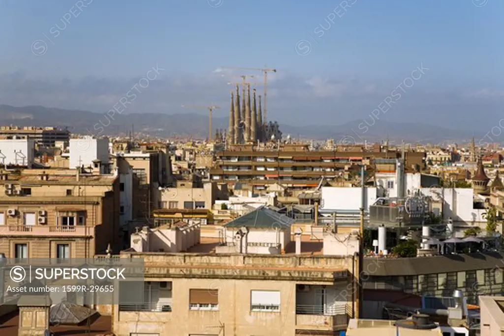 Barcelona skyline with distant view of Sagrada Familia Holy Family Church by architect Antoni Gaudi, Barcelona, Spain begun in 1882 and continuing to be built into the 21st Century