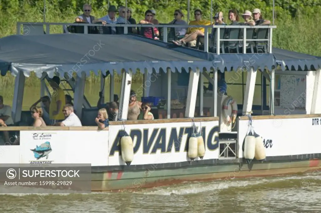 Tourists on boat cruise river for hippos' at Greater St. Lucia Wetland Park World Heritage Site, St. Lucia, South Africa