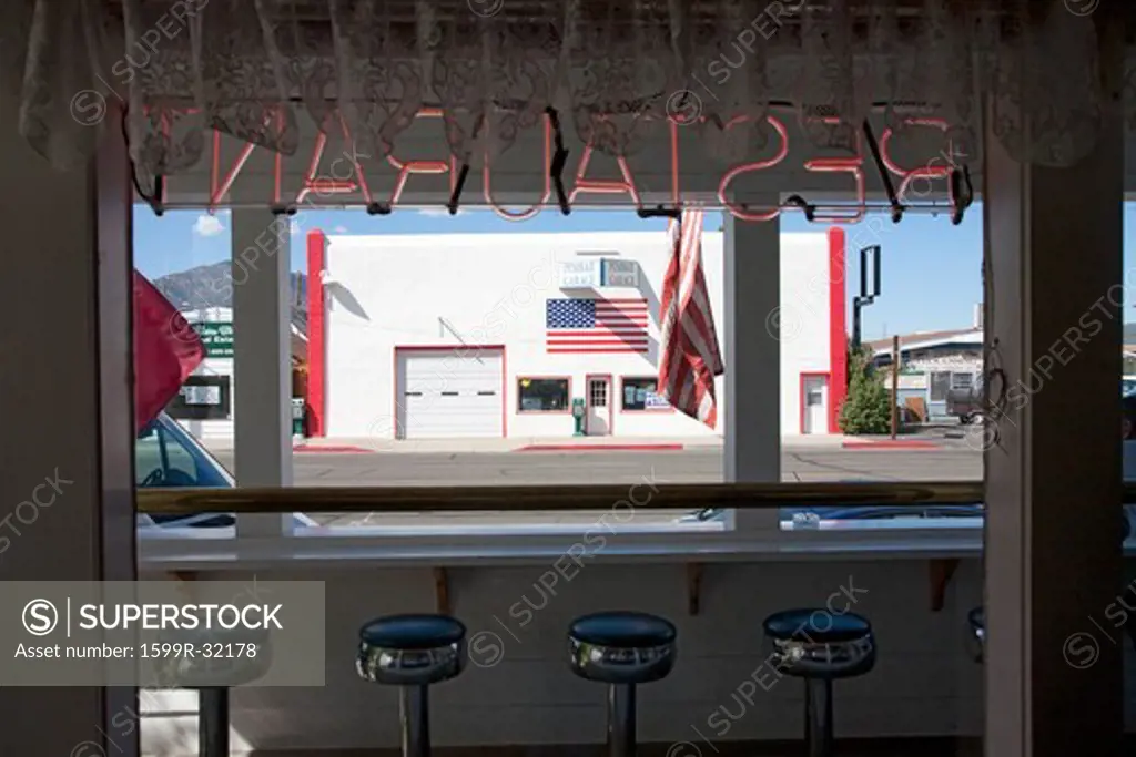 Inside out view of Penbar Garage from local restaurant with bar stools, Bridgeport, CA