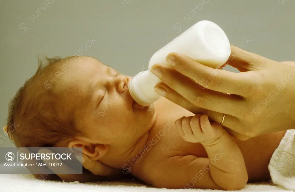 Newborn child, lying, drinking from baby's bottle, woman's hand holding his head