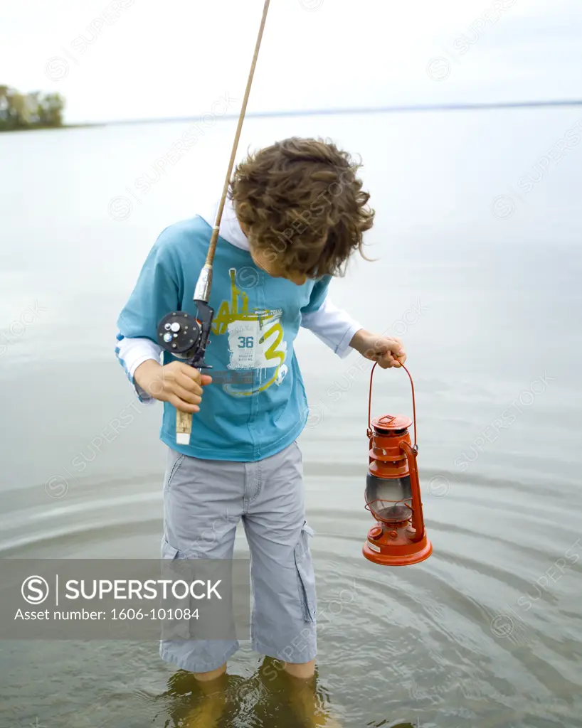 Boy with fishing rod and storm lantern